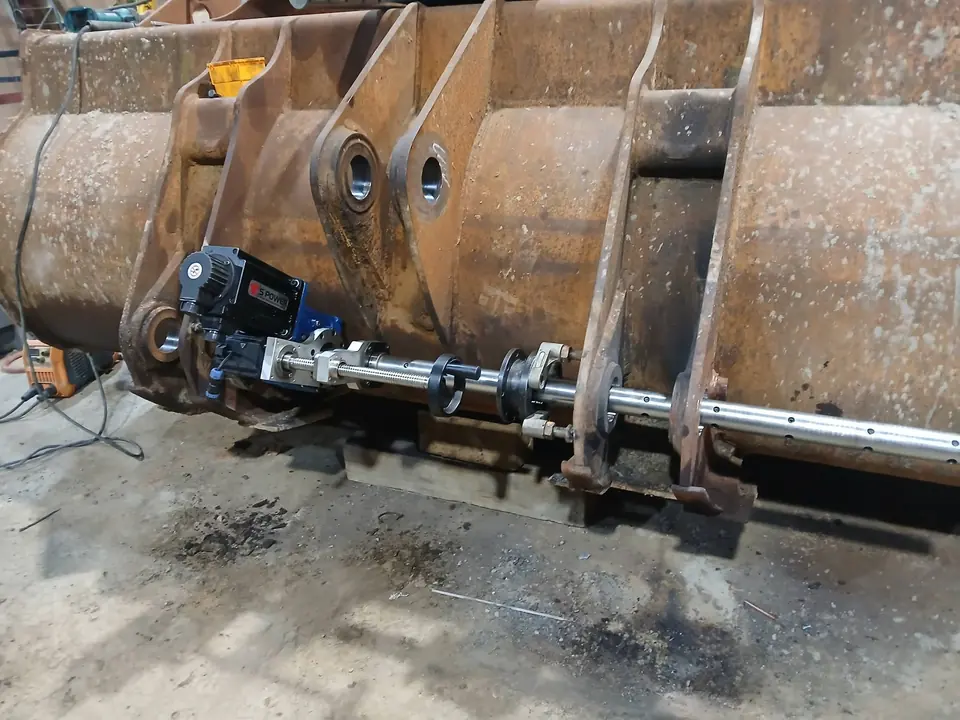 Line boring bar set up along a bucket resting on a workshop floor