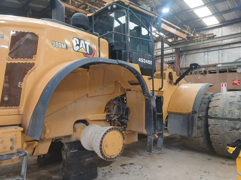 Wheel loader up in the workshop with a wheel and drive removed