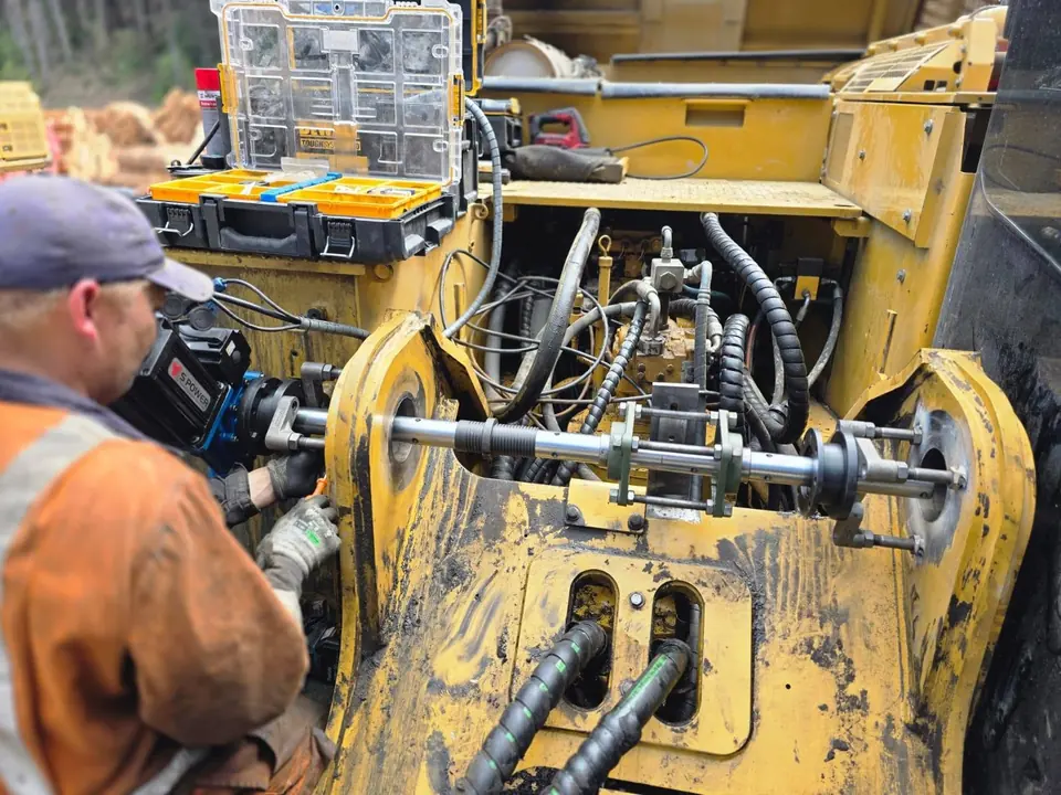 Technician working on the hydraulics of a heavy machine