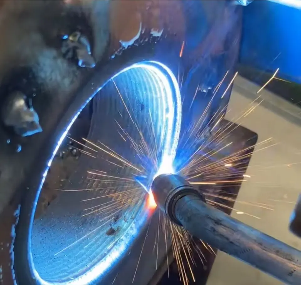 Close view of the welding arc and sparks as weld is laid into a bore