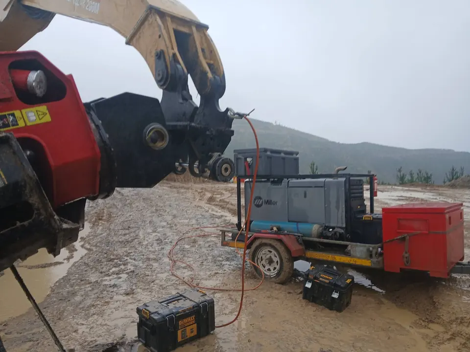 Welding plant and power pack set up on the ground beside a machine being worked on